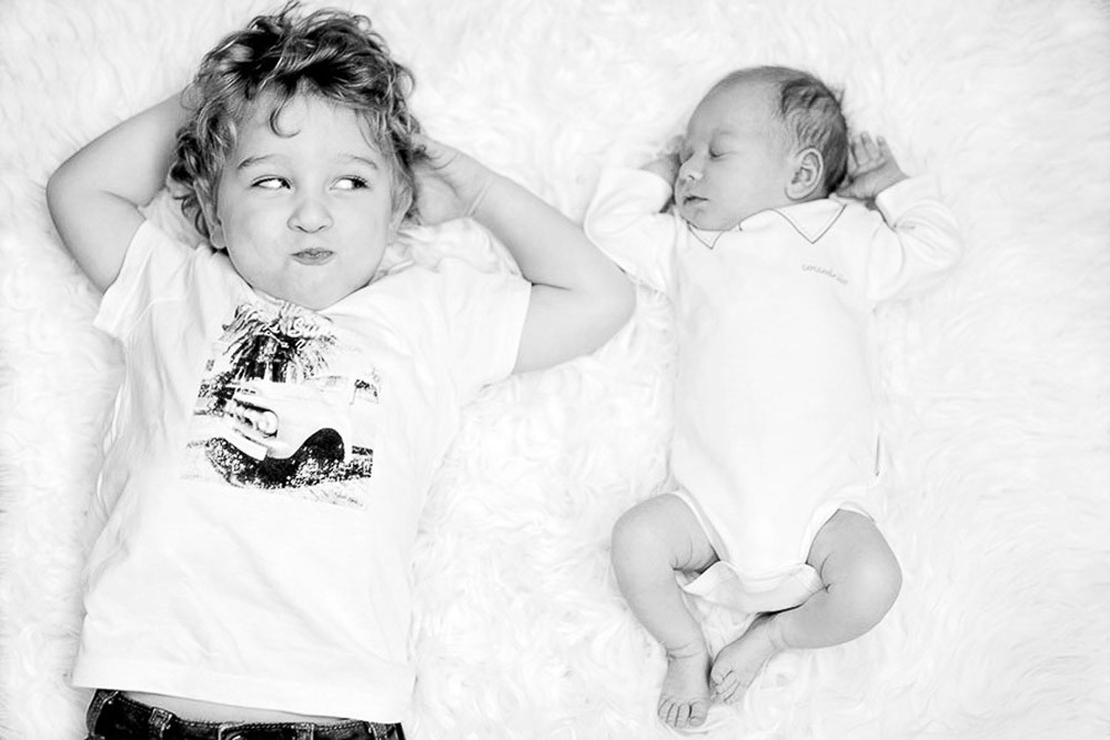 black and white portrait with newborn siblings