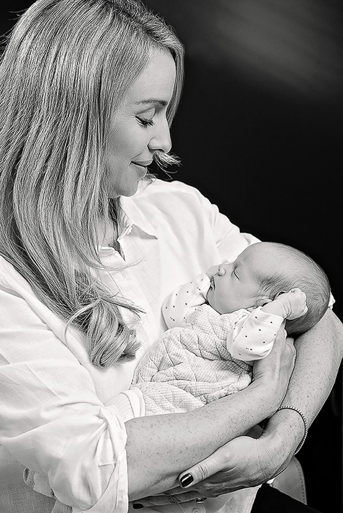newborn sleeping in her mother's arm during a relaxed home newborn session