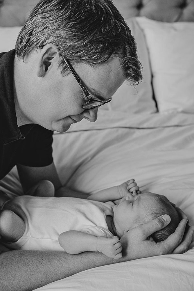 black and white photo of father and newborn baby